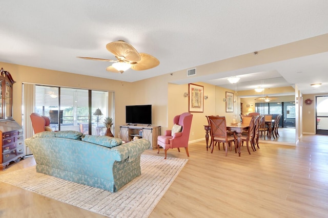 living room with ceiling fan and light hardwood / wood-style floors