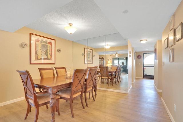 dining space featuring a textured ceiling, light hardwood / wood-style flooring, and ceiling fan