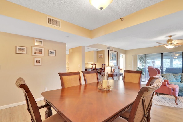 dining space featuring a textured ceiling, light hardwood / wood-style floors, and ceiling fan