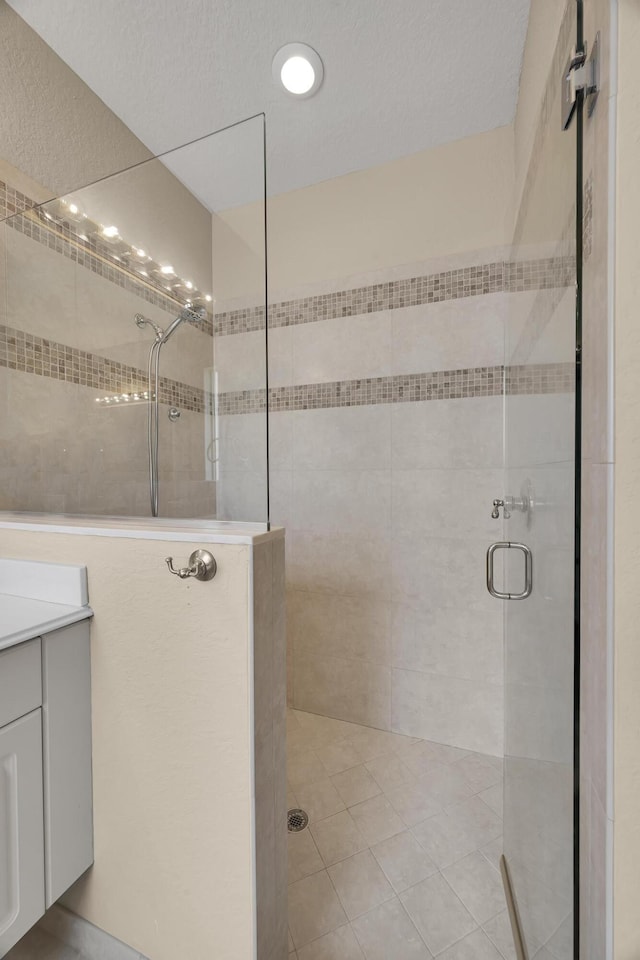 full bath featuring vanity and a tile shower