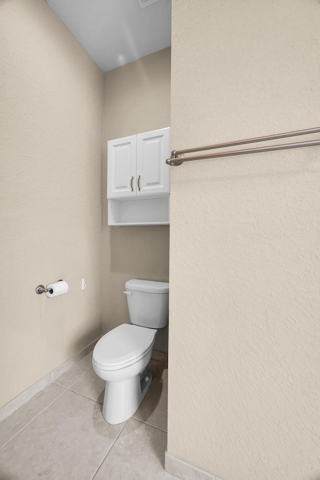 bathroom with tile patterned flooring, toilet, and baseboards