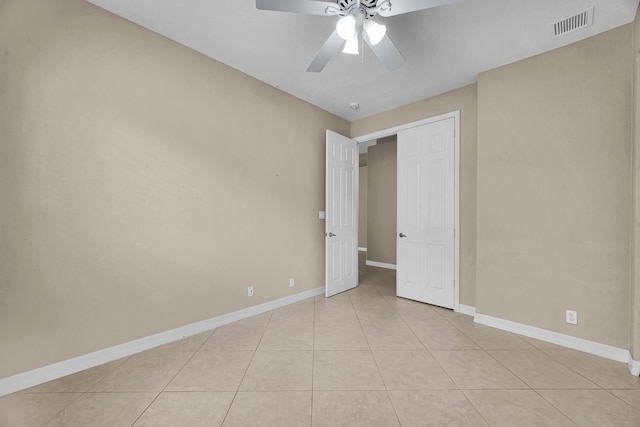 unfurnished bedroom with light tile patterned floors, visible vents, baseboards, and a ceiling fan