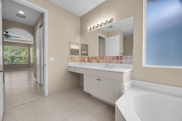 bathroom featuring tile patterned flooring, visible vents, ceiling fan, a bath, and vanity