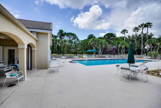 community pool featuring a patio area and fence