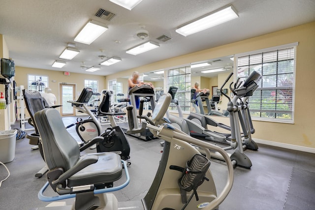 workout area featuring a healthy amount of sunlight, visible vents, and a textured ceiling