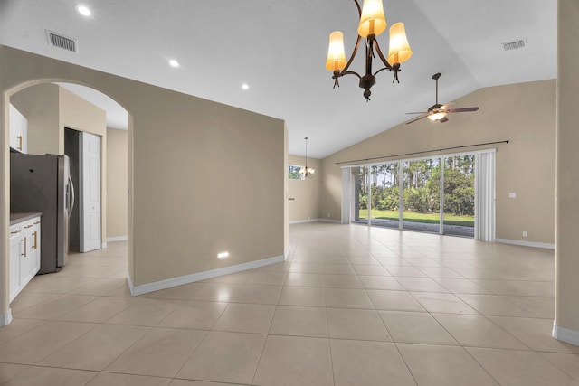 empty room with light tile patterned floors, visible vents, baseboards, and vaulted ceiling