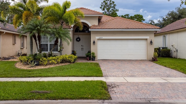 mediterranean / spanish home featuring stucco siding, decorative driveway, a garage, and a tile roof