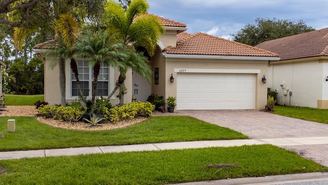 view of front of house featuring an attached garage, stucco siding, a front lawn, a tiled roof, and decorative driveway