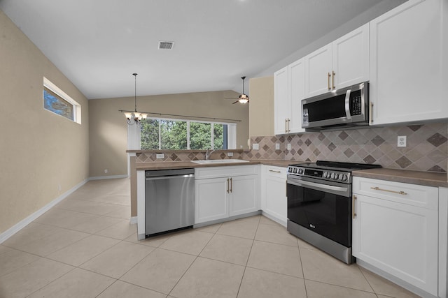 kitchen with a sink, lofted ceiling, tasteful backsplash, and appliances with stainless steel finishes