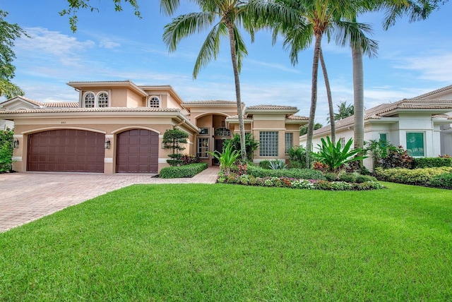 mediterranean / spanish-style house featuring a front yard and a garage