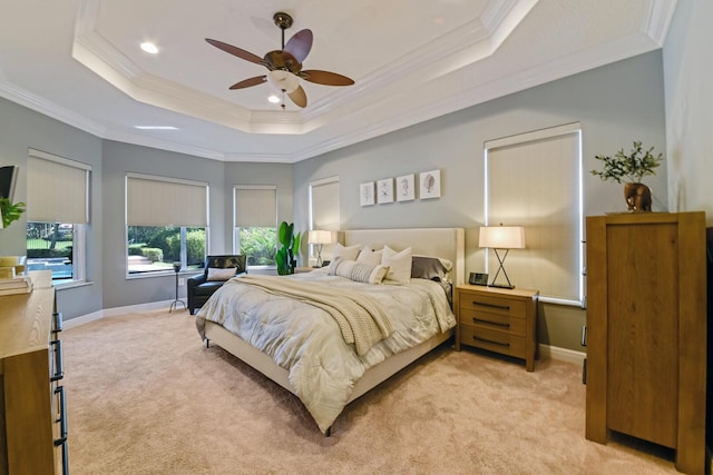 carpeted bedroom featuring a tray ceiling, ceiling fan, and crown molding