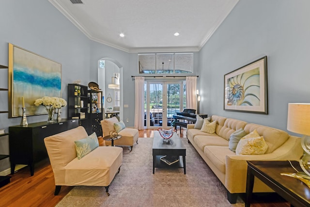 living room with wood-type flooring, crown molding, and french doors