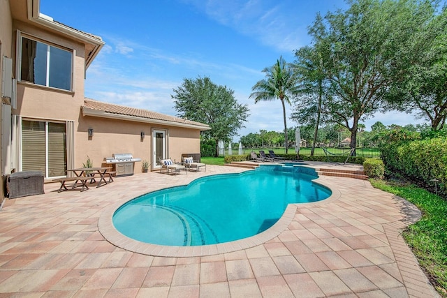 view of pool featuring a grill and a patio