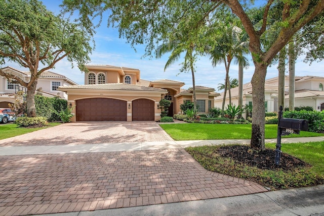 mediterranean / spanish home featuring a front lawn and a garage