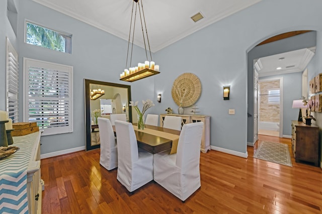 dining space with crown molding, a healthy amount of sunlight, and wood-type flooring