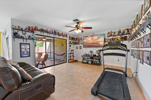 exercise area with ceiling fan and light tile patterned floors