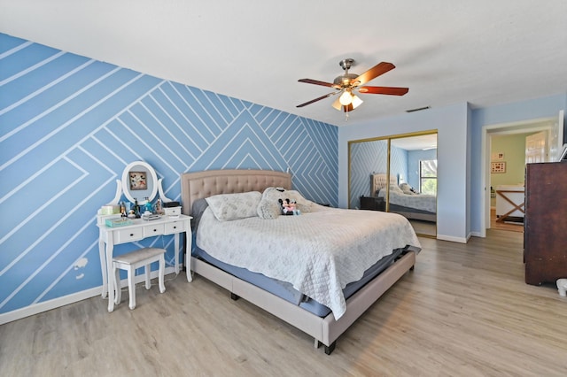 bedroom featuring hardwood / wood-style flooring, ceiling fan, and a closet