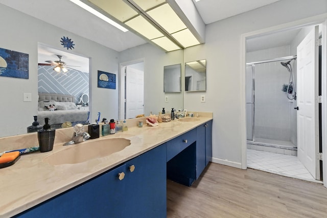 bathroom featuring hardwood / wood-style flooring, vanity, ceiling fan, and an enclosed shower