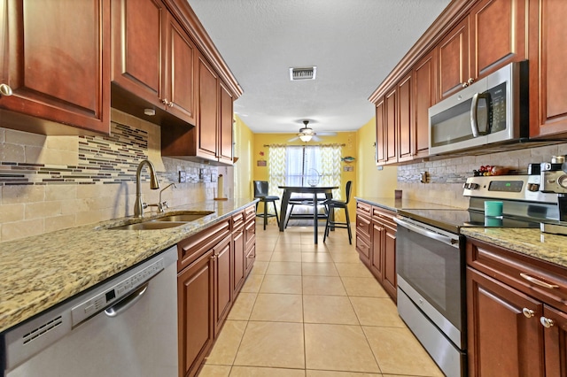 kitchen with backsplash, stainless steel appliances, ceiling fan, sink, and light tile patterned floors