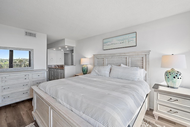 bedroom featuring a textured ceiling and dark wood-type flooring