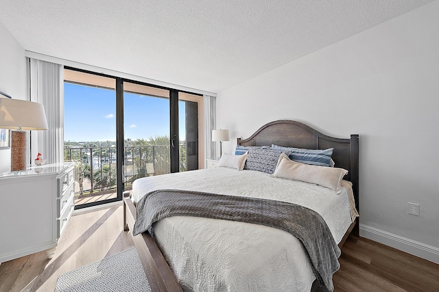 bedroom featuring floor to ceiling windows, a textured ceiling, and wood-type flooring