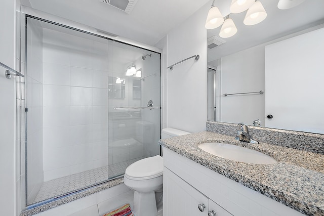 bathroom with an enclosed shower, vanity, and toilet