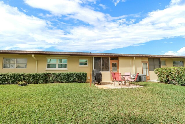 rear view of property with a patio area, a yard, and central AC