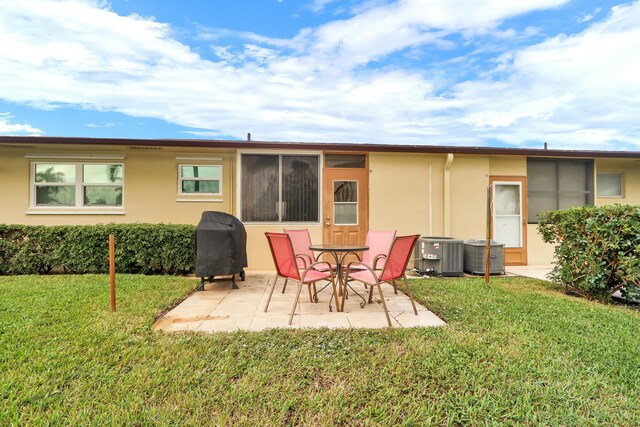 back of property with a patio, central air condition unit, and a lawn