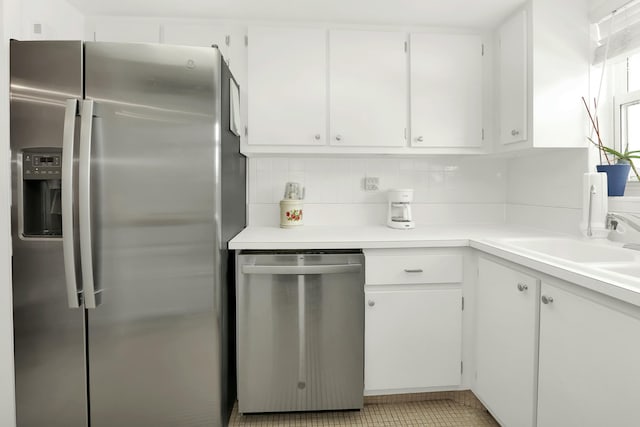 kitchen with white cabinets, decorative backsplash, and stainless steel appliances