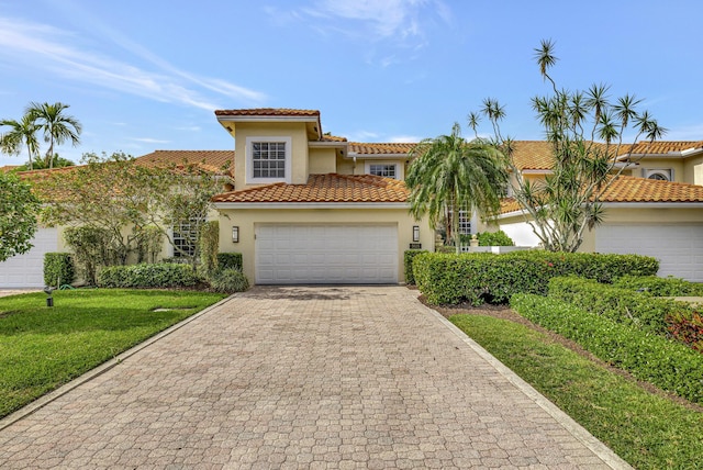 mediterranean / spanish home with a garage and a front yard