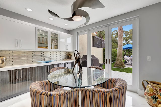 dining space with french doors, ceiling fan, and light tile patterned flooring