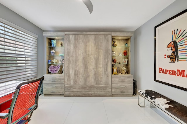 interior space featuring light tile patterned floors and ceiling fan