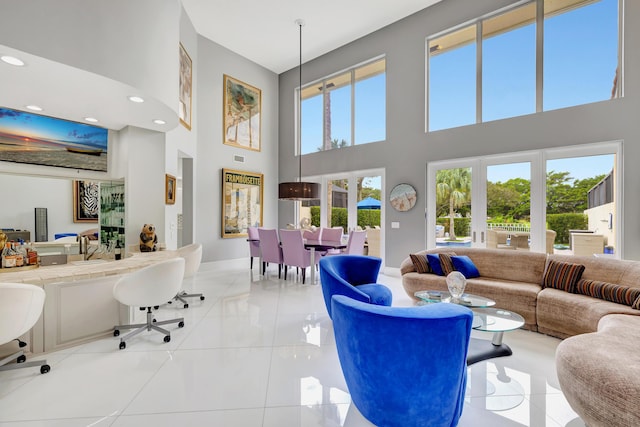 living room featuring a towering ceiling and light tile patterned floors