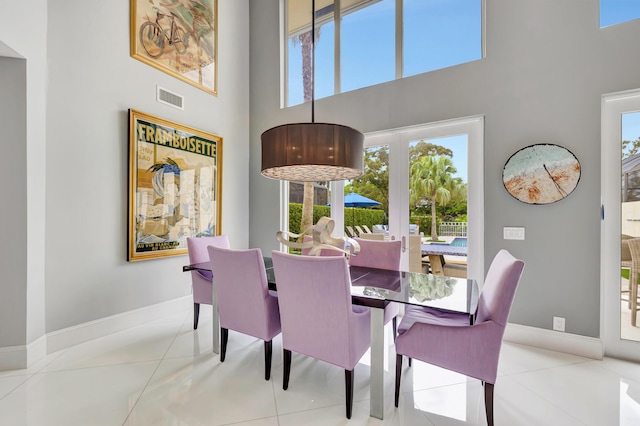 tiled dining area with a high ceiling