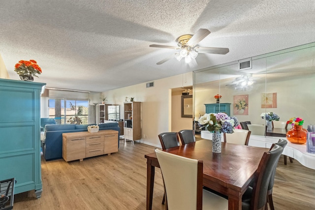 dining room featuring ceiling fan, a textured ceiling, and light wood-type flooring