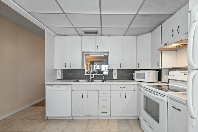 kitchen with sink, a drop ceiling, tasteful backsplash, white appliances, and white cabinets