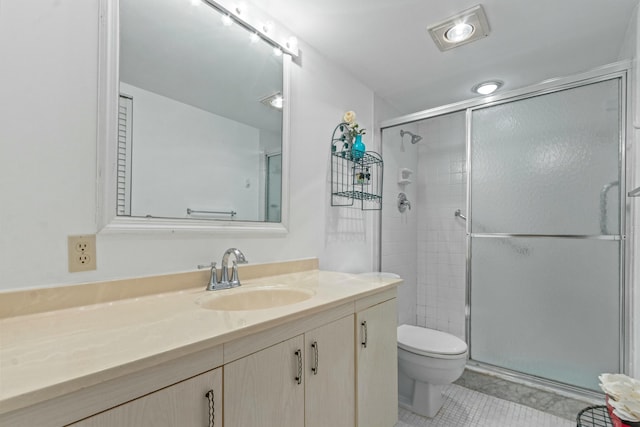 bathroom with toilet, vanity, tile patterned floors, and a shower with shower door