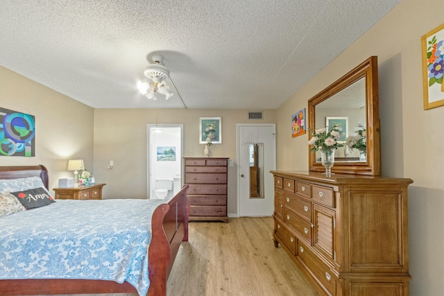 bedroom featuring ceiling fan, light hardwood / wood-style floors, and a textured ceiling