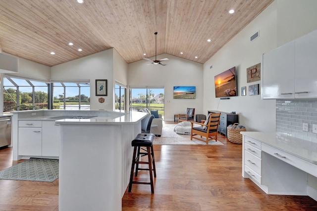 kitchen with wooden ceiling, high vaulted ceiling, white cabinets, ceiling fan, and tasteful backsplash