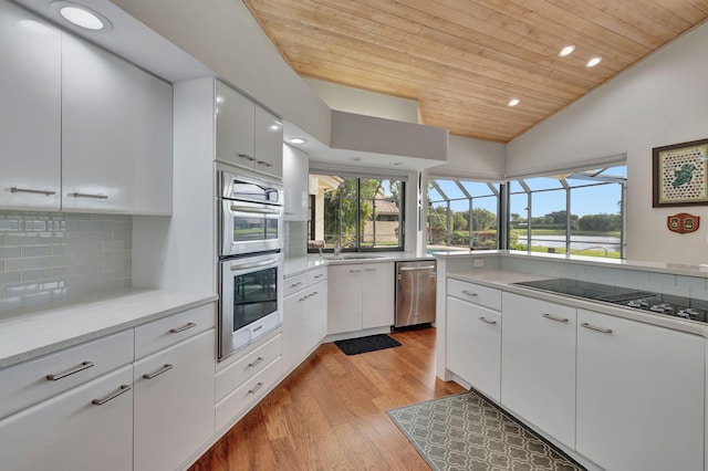 kitchen featuring white cabinetry, tasteful backsplash, light hardwood / wood-style floors, wood ceiling, and appliances with stainless steel finishes