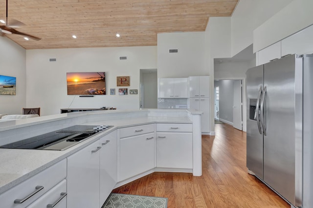 kitchen featuring stainless steel refrigerator with ice dispenser, light hardwood / wood-style floors, black electric cooktop, white cabinets, and wood ceiling