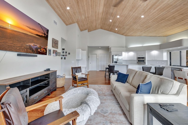 living room with light hardwood / wood-style floors, high vaulted ceiling, and wooden ceiling