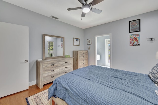 bedroom with ceiling fan, light wood-type flooring, and ensuite bath