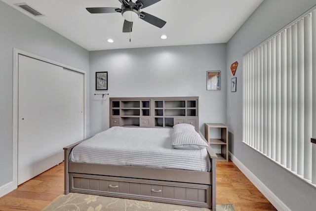 bedroom with ceiling fan, light hardwood / wood-style floors, and a closet