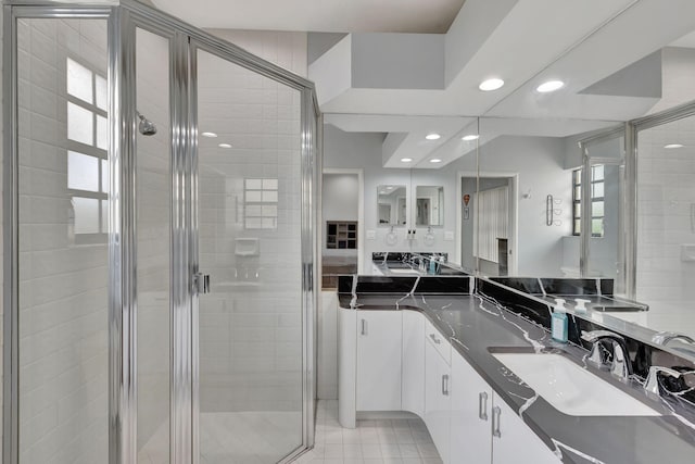 bathroom with tile patterned flooring, vanity, and a shower with door