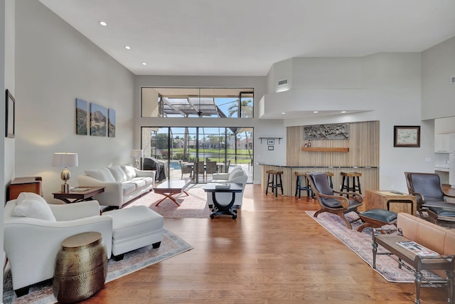 living room featuring hardwood / wood-style floors and a towering ceiling