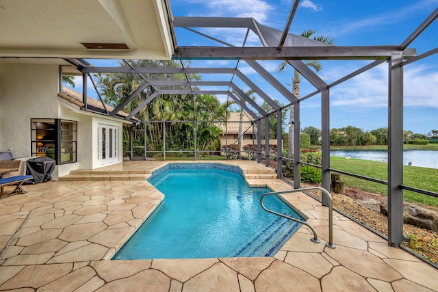 view of swimming pool with glass enclosure, a patio area, a water view, and french doors