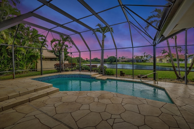 pool at dusk featuring a lanai, a water view, and a patio