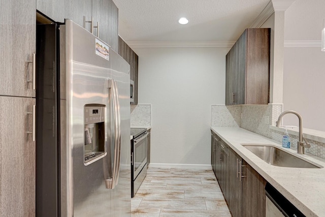 kitchen featuring appliances with stainless steel finishes, tasteful backsplash, crown molding, and sink