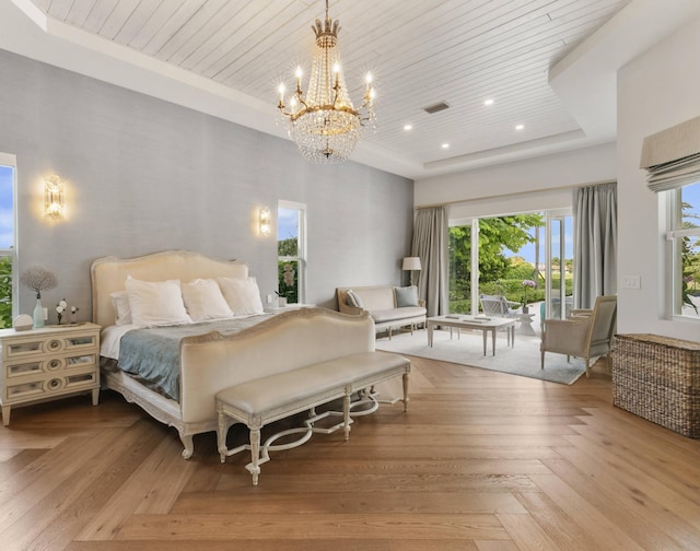 bedroom featuring light parquet floors, wood ceiling, a tray ceiling, and a notable chandelier